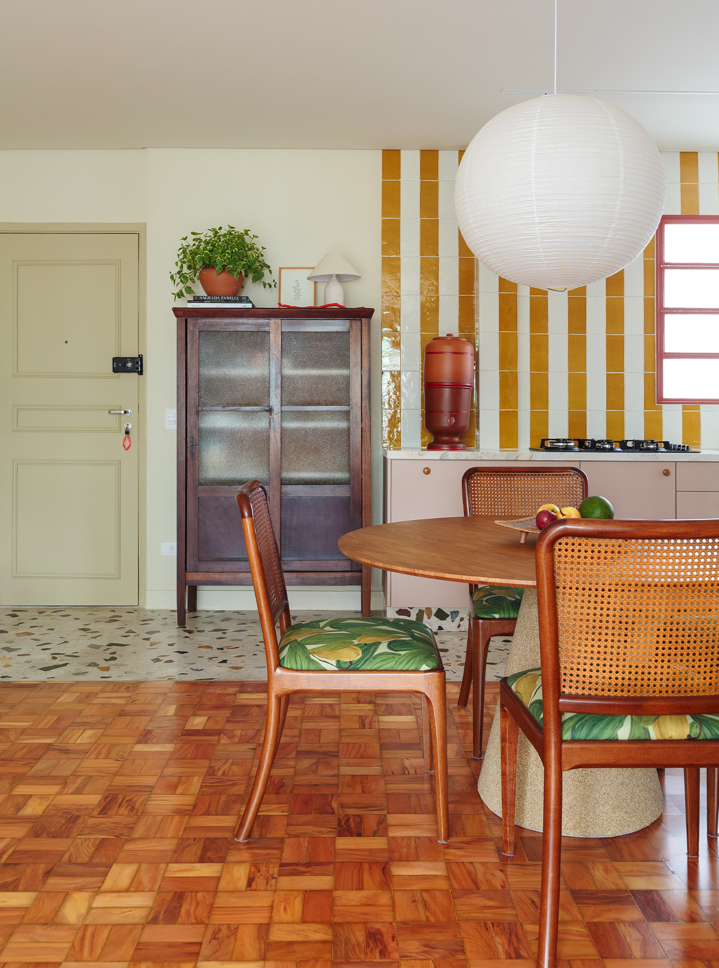 Apartamento reformado com decoração colorida, esquadrias vermelhas e cozinha listrada de amarelo
