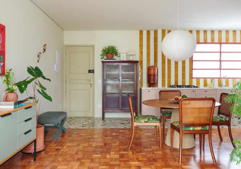 Apartamento reformado com decoração colorida, esquadrias vermelhas e cozinha listrada de amarelo