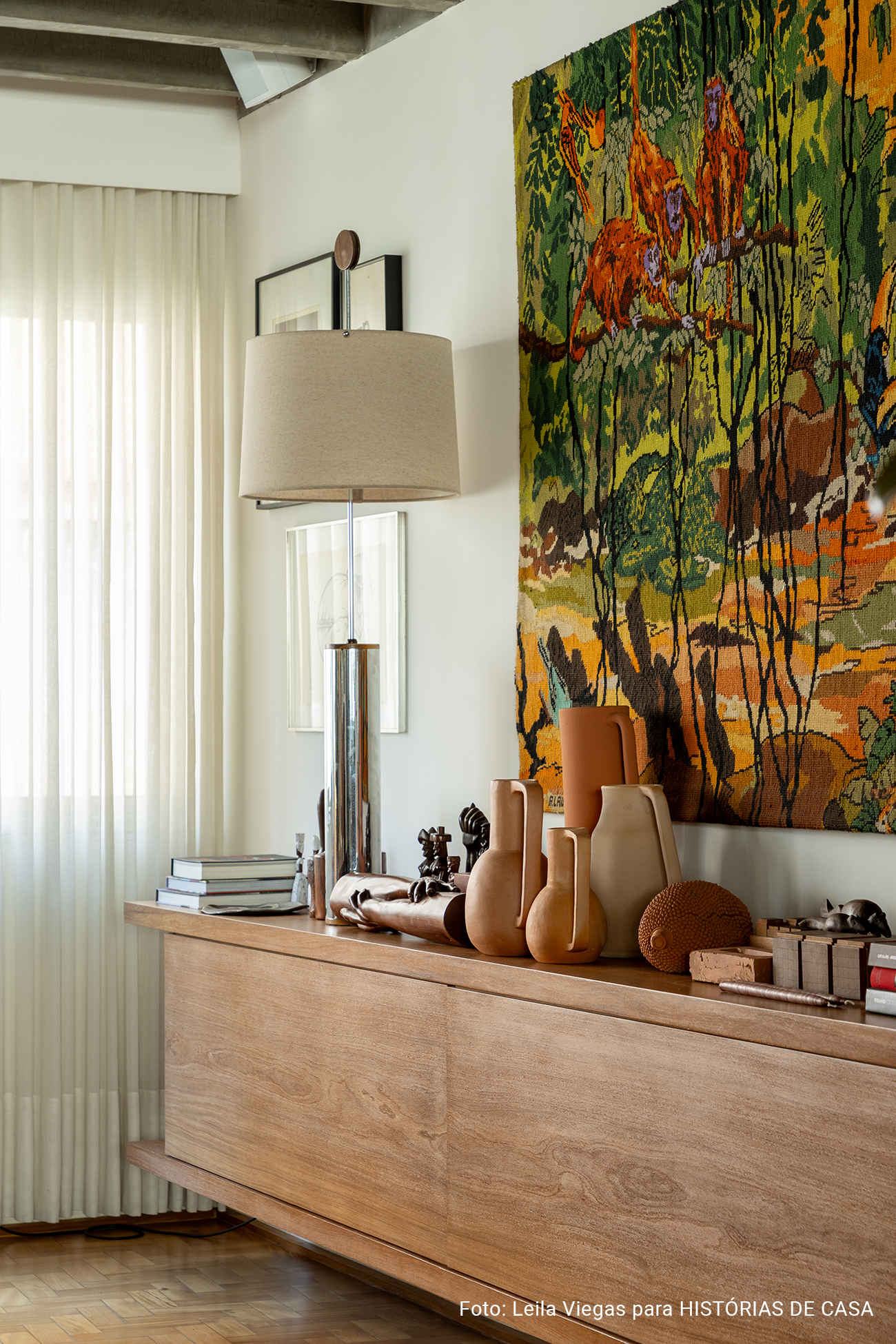 Apartamento de Ademir e André Bueno em Higienópolis, com laje de concreto aparente, ambientes integrados e obras de arte