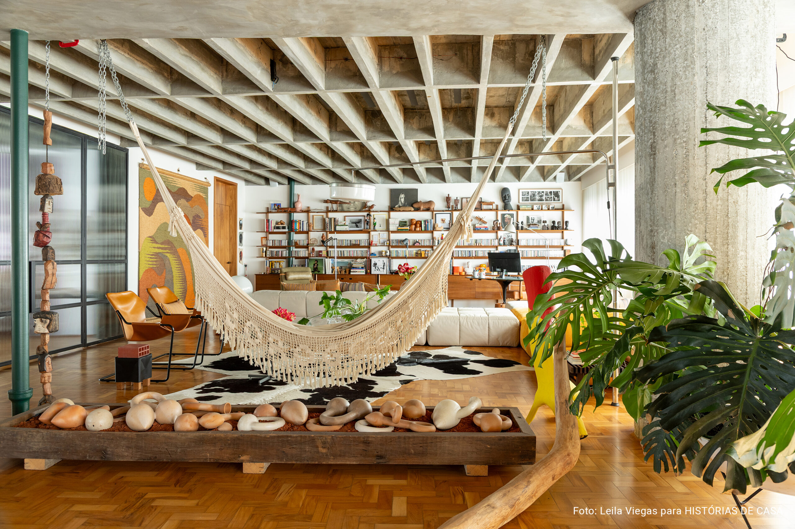 Apartamento de Ademir e André Bueno em Higienópolis, com laje de concreto aparente, ambientes integrados e obras de arte