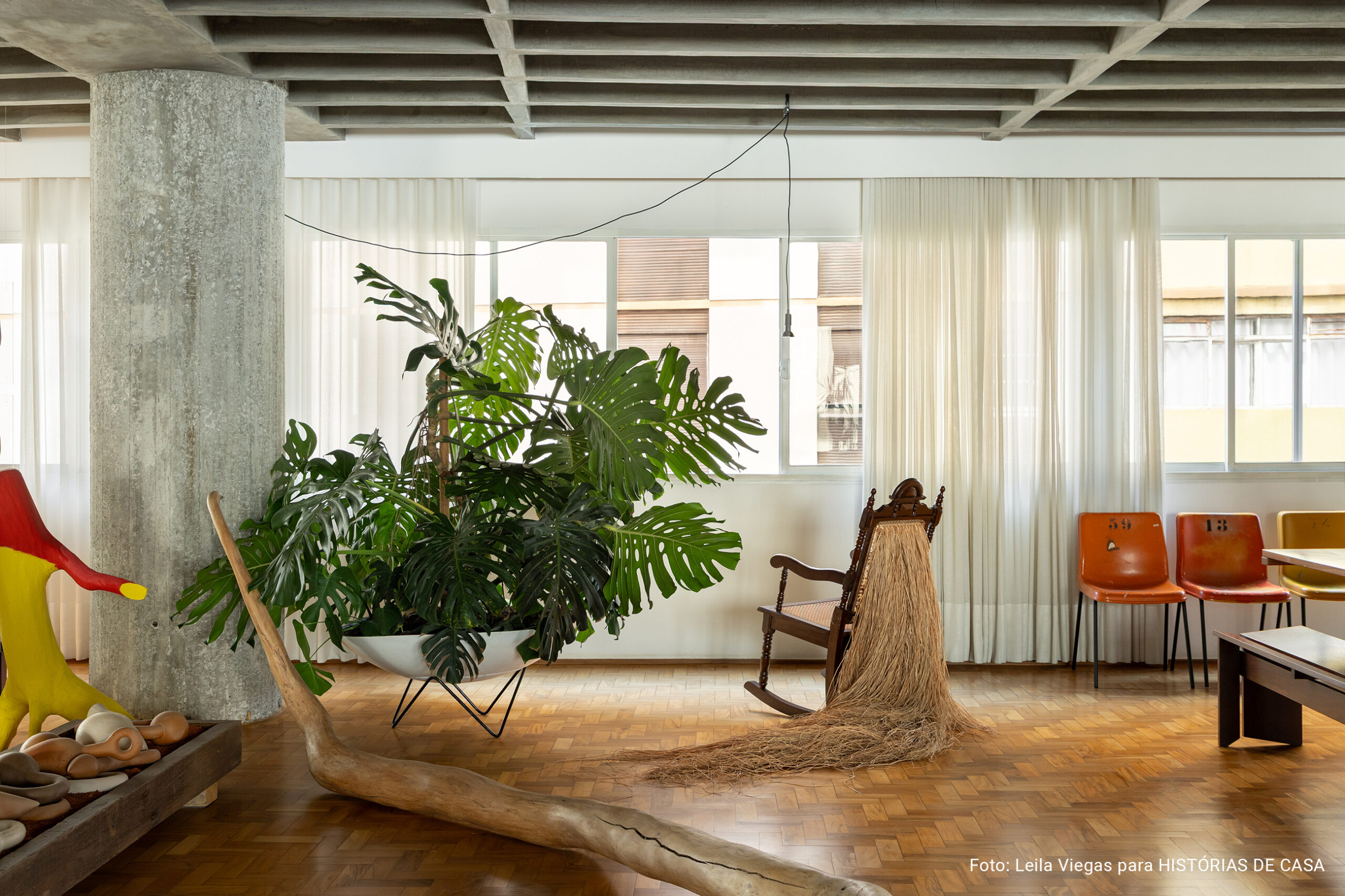 Apartamento de Ademir e André Bueno em Higienópolis, com laje de concreto aparente, ambientes integrados e obras de arte
