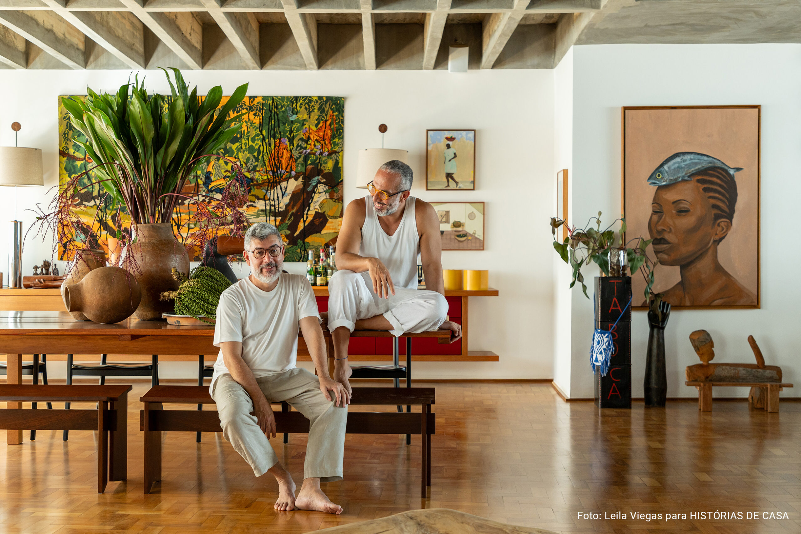 Apartamento de Ademir e André Bueno em Higienópolis, com laje de concreto aparente, ambientes integrados e obras de arte