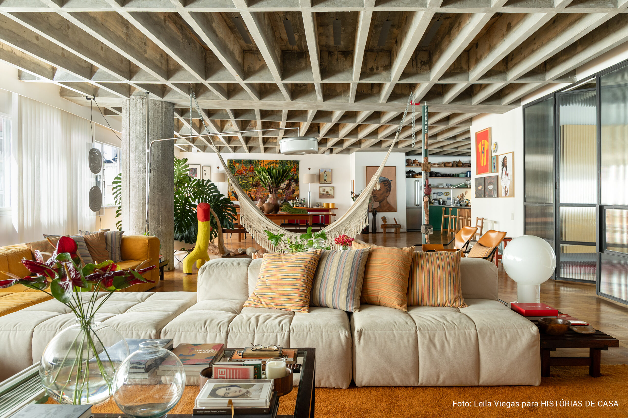 Apartamento de Ademir e André Bueno em Higienópolis, com laje de concreto aparente, ambientes integrados e obras de arte
